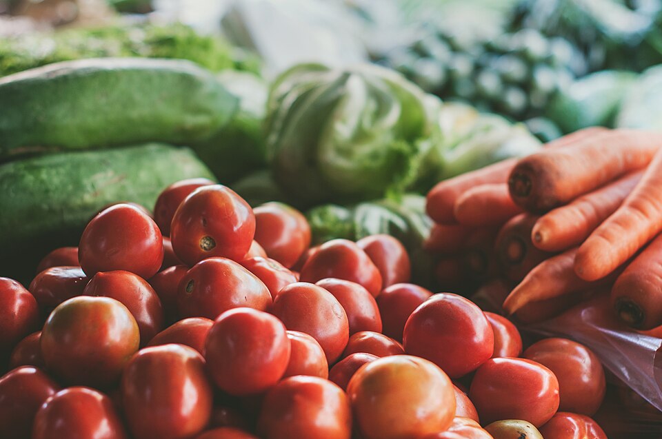 Banca de hortifrúti com tomate, repolho e cenoura
